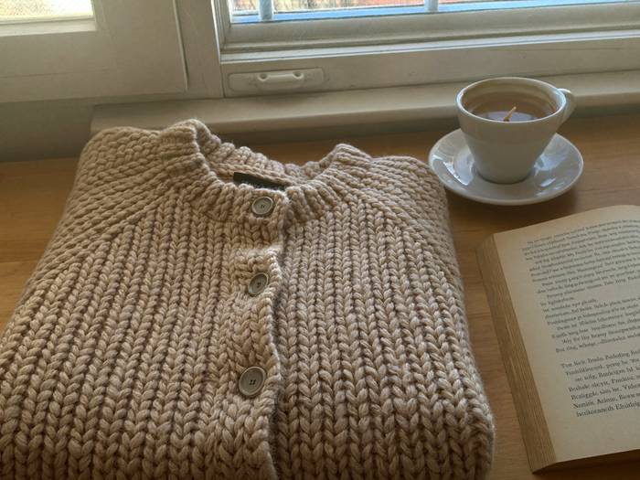 Strickcardigan auf einem Holztisch