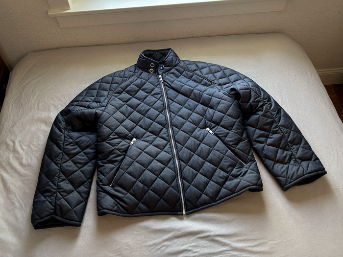 Navyblaue Steppjacke auf einem Bett